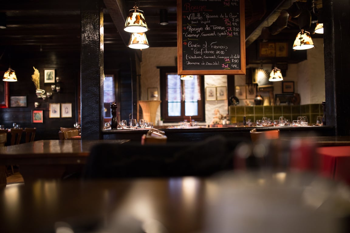 Comfy Tavern vibes with warm lighting and a wine menu on a chalkboard hanging